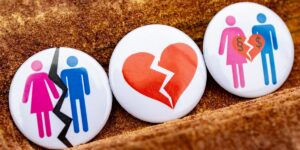 Three buttons with people and a broken heart on them