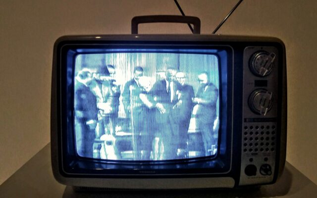 black crt tv turned on on white table